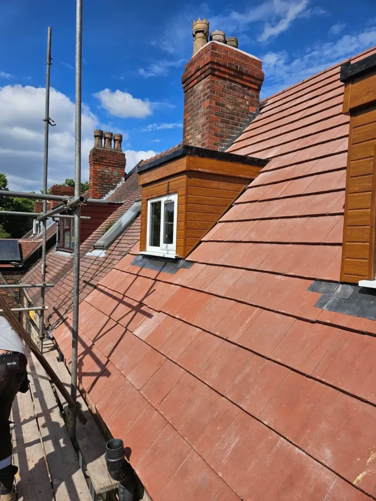 Dormer and chimneys with new red roof tiles