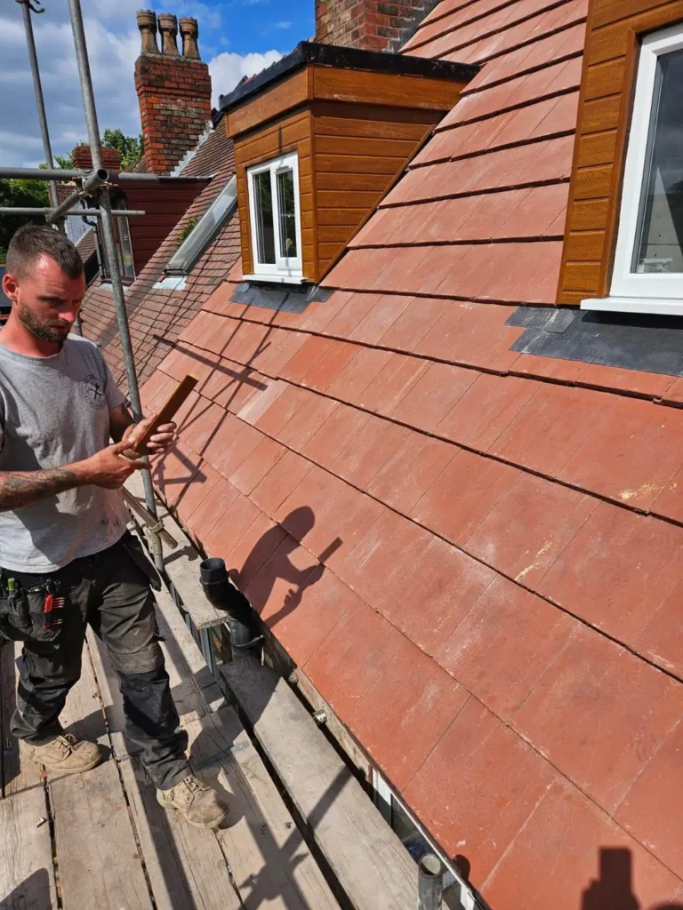 Roofer at work beside a new dormer