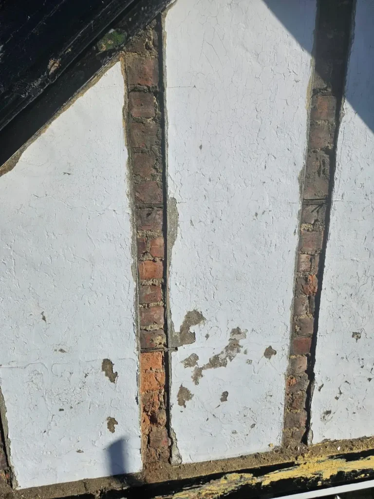 Repaired mock-Tudor render and timber on a gable